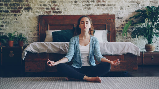 Woman meditating peacefully in a bedroom