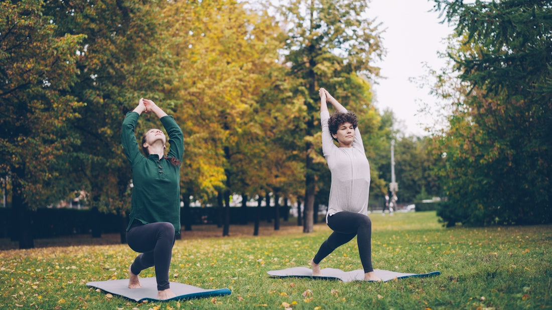 Two people doing yoga in a park